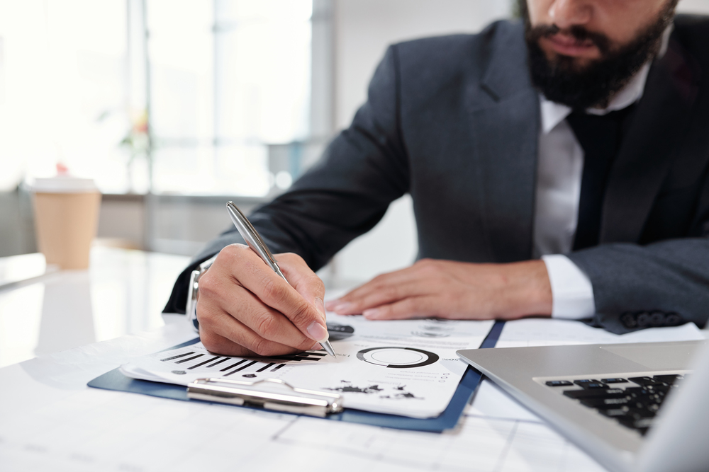 businessman writing on clipboard closeup